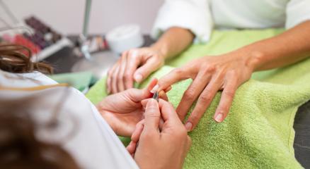 Manicurist trimming cuticles of a client at a salon with tools on table  in a beauty salon. body care spa treatment concept image- Stock Photo or Stock Video of rcfotostock | RC Photo Stock