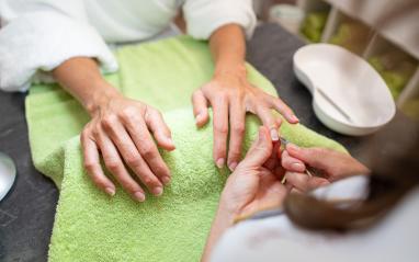 Manicurist trimming cuticles of a female client at a salon with tools on table in a beauty salon- Stock Photo or Stock Video of rcfotostock | RC Photo Stock