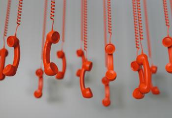 many red telephone receivers hanging over gray background concept hold or contact us - Stock Photo or Stock Video of rcfotostock | RC Photo Stock