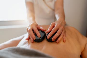 Massage therapist using hot stones on client's back during a spa treatment. Wellness Hotel Concept image : Stock Photo or Stock Video Download rcfotostock photos, images and assets rcfotostock | RC Photo Stock.: