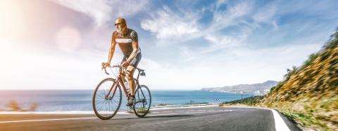 Mature Adult on a racing bike climbing the hill at mediterranean sea landscape coastal road- Stock Photo or Stock Video of rcfotostock | RC-Photo-Stock