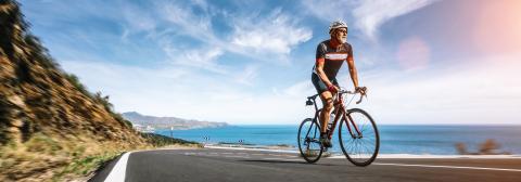 Mature Adult on a racing bike climbing the hill at mediterranean sea landscape coastal road : Stock Photo or Stock Video Download rcfotostock photos, images and assets rcfotostock | RC Photo Stock.: