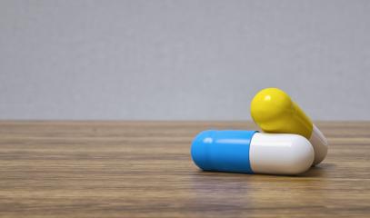 Medicine blue and yellow pills or capsules on a wooden table with copy space for individual text- Stock Photo or Stock Video of rcfotostock | RC Photo Stock