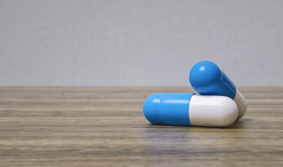 Medicine blue pills or capsules on a wooden table with copy space for individual text- Stock Photo or Stock Video of rcfotostock | RC-Photo-Stock