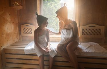 Mother and daughter enjoying a sauna session, wearing felt hats and wrapped in towels- Stock Photo or Stock Video of rcfotostock | RC Photo Stock