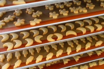 Multiple trays of freshly baked Christmas cookies in various festive shapes, such as moons and stars, are cooling on silicone baking mats in a bakery, ready for packaging or decorating : Stock Photo or Stock Video Download rcfotostock photos, images and assets rcfotostock | RC Photo Stock.: