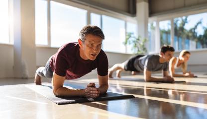 muscular man and woman doing planking exercises in gym on a yoga mat position on elbows while training in studio- Stock Photo or Stock Video of rcfotostock | RC Photo Stock