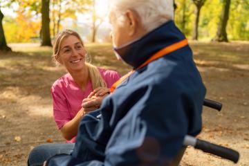 Nurse smiling and holding hands with elderly man in wheelchair, autumn leaves and sunlight in background : Stock Photo or Stock Video Download rcfotostock photos, images and assets rcfotostock | RC Photo Stock.: