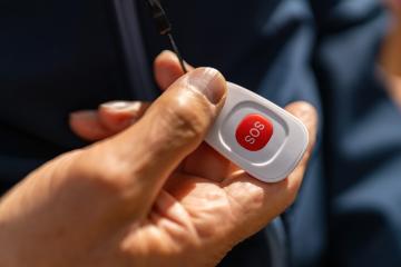 old hand holding an SOS button, highlighting its use for emergencies with focus on the red button- Stock Photo or Stock Video of rcfotostock | RC Photo Stock