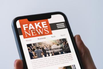 Online fake news on a mobile phone. Close up of woman reading Fake news HOAX or articles in a smartphone screen application. Hand holding smart device. Mockup website. Fake Newspaper portal.- Stock Photo or Stock Video of rcfotostock | RC Photo Stock