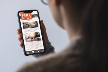 Online fake news on a mobile phone. Close up of woman reading Fake news HOAX or articles in a smartphone screen application. Hand holding smart device. Mockup website. Fake Newspaper portal. : Stock Photo or Stock Video Download rcfotostock photos, images and assets rcfotostock | RC Photo Stock.: