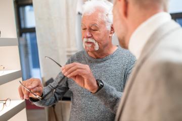Optician conducts a consultation with a senior men examining eyeglasses in a optical store- Stock Photo or Stock Video of rcfotostock | RC Photo Stock