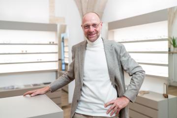 optician wearing glasses smiling in an eyewear shop. He is weari : Stock Photo or Stock Video Download rcfotostock photos, images and assets rcfotostock | RC Photo Stock.: