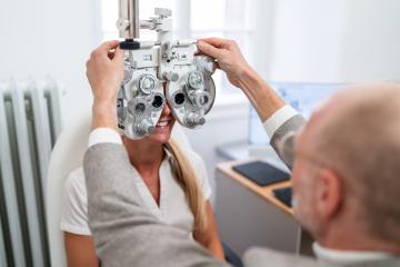 Optometrist adjusting a phoropter for a patient during an eye te- Stock Photo or Stock Video of rcfotostock | RC Photo Stock