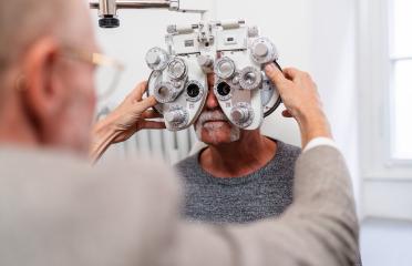 Optometrist adjusting phoropter for senior patient's vision test- Stock Photo or Stock Video of rcfotostock | RC Photo Stock