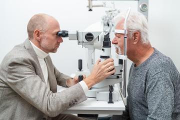Optometrist examining the eyes of a senior male patient using a - Stock Photo or Stock Video of rcfotostock | RC Photo Stock