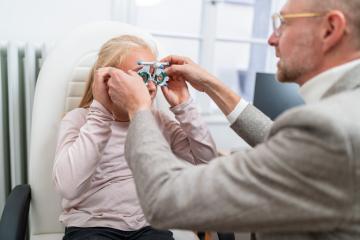 Optometrist fitting Optical measuring glasses on a young blonde - Stock Photo or Stock Video of rcfotostock | RC Photo Stock