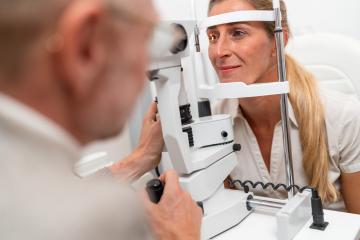 Optometrist undergoing on a patient an eye examination with a focus on her illuminated eye using a slit lamp at the clinic. Close-up photo. Healthcare and medicine concept- Stock Photo or Stock Video of rcfotostock | RC Photo Stock
