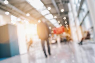 People walking on a trade show hall with booths, generic background with a blur effect applied- Stock Photo or Stock Video of rcfotostock | RC Photo Stock