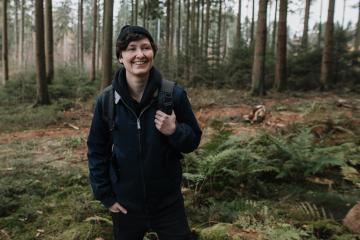 personable person in an impressive, beautiful forest laughs naturally. Young modern hipster tourist in nature while hiking.- Stock Photo or Stock Video of rcfotostock | RC Photo Stock