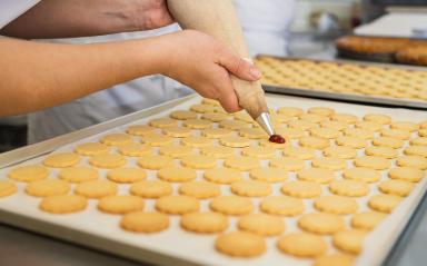 Piping red jam onto freshly baked cookies arranged on a baking sheet. Rows of plain cookies are being prepared for assembly, creating a jam-filled sandwich cookie. : Stock Photo or Stock Video Download rcfotostock photos, images and assets rcfotostock | RC Photo Stock.: