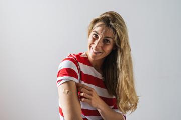 Portrait of a woman after getting a vaccine injection. Woman holding up her shirt sleeve and showing her arm with Adhesive bandage Plaster after receiving vaccination, copyspace for your individual - Stock Photo or Stock Video of rcfotostock | RC Photo Stock