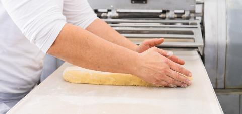 Preparing cookie dough by shaping it with hands on a work surface in a bakery, getting the dough ready for rolling and cutting in a professional baking environment : Stock Photo or Stock Video Download rcfotostock photos, images and assets rcfotostock | RC Photo Stock.: