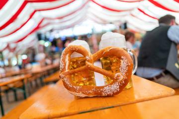 pretzel and beer mugs on a table at Oktoberfest or dult. The frothy beer and vibrant red and white tent background create a festive and lively atmosphere in munich : Stock Photo or Stock Video Download rcfotostock photos, images and assets rcfotostock | RC Photo Stock.: