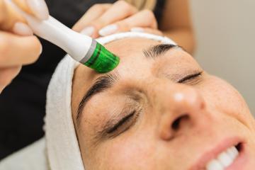 Professional cosmetology. Smart skilled cosmetologist using a modern device while doing aquafacial procedure at a  cosmetology salon.- Stock Photo or Stock Video of rcfotostock | RC Photo Stock