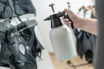 rainer use a spray bottle to preparing ems vest with water for training in a EMS Studio- Stock Photo or Stock Video of rcfotostock | RC Photo Stock
