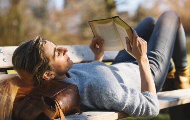 Reading woman laying in the park on her bag at a bench.  student reading a book concept image : Stock Photo or Stock Video Download rcfotostock photos, images and assets rcfotostock | RC Photo Stock.: