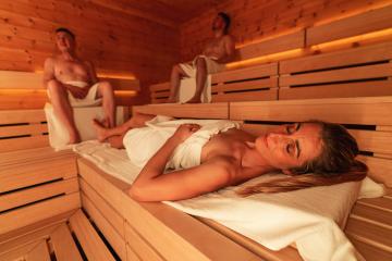 Reclining woman and seated men in a wooden Finnish sauna, warm ambient light : Stock Photo or Stock Video Download rcfotostock photos, images and assets rcfotostock | RC Photo Stock.: