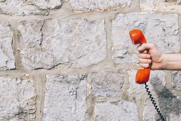 red telephone receiver against a stone wall- Stock Photo or Stock Video of rcfotostock | RC Photo Stock