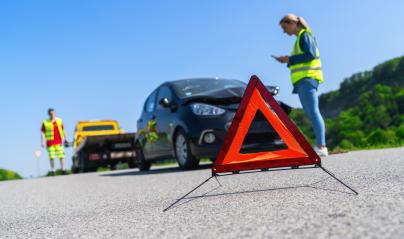 Red warning triangle on road with woman using smartphone and Roadside assistance worker on a tow truck in background. Roadside assistance concept image. : Stock Photo or Stock Video Download rcfotostock photos, images and assets rcfotostock | RC Photo Stock.: