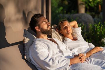 Relaxed couple in white robes lounging outdoors in the sunlight- Stock Photo or Stock Video of rcfotostock | RC Photo Stock
