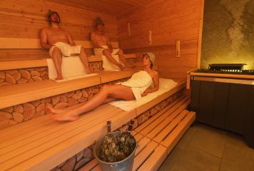 Relaxed individuals in a finnish sauna, two men sitting with felt hats and a woman lying down with a bucket and vihta on the bench : Stock Photo or Stock Video Download rcfotostock photos, images and assets rcfotostock | RC Photo Stock.: