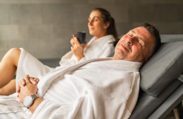 Relaxed man with eyes closed in spa, woman in background holding a mug : Stock Photo or Stock Video Download rcfotostock photos, images and assets rcfotostock | RC Photo Stock.: