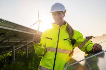 Renewable energy technician holding a wind turbine model at solar farm. Alternative energy ecological concept image.- Stock Photo or Stock Video of rcfotostock | RC Photo Stock