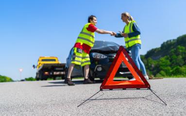 Roadside assistance worker and customer in high visibility vests shaking hands near a tow truck and a warning triangle on a sunny road : Stock Photo or Stock Video Download rcfotostock photos, images and assets rcfotostock | RC Photo Stock.: