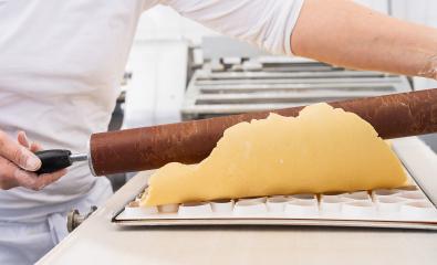 Rolling out cookie dough over a cookie cutter mold using a wooden rolling pin in a bakery, shaping the dough for cutting in a professional baking environment : Stock Photo or Stock Video Download rcfotostock photos, images and assets rcfotostock | RC Photo Stock.: