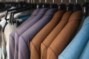 Row of suits on hangers, varying shades of brown and blue, formal wear display at a store- Stock Photo or Stock Video of rcfotostock | RC Photo Stock