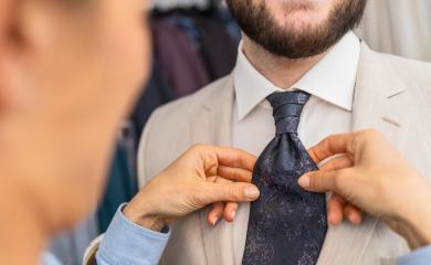 Saleswoman adjusting a tie on a man in a beige suit : Stock Photo or Stock Video Download rcfotostock photos, images and assets rcfotostock | RC Photo Stock.: