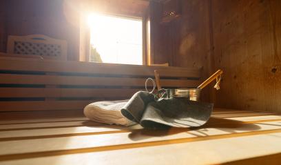 Sauna interior with felt hats, towels, ladle, and bucket, sunlight through window in a finnish sauna. Spa wellness hotel concept image.- Stock Photo or Stock Video of rcfotostock | RC Photo Stock