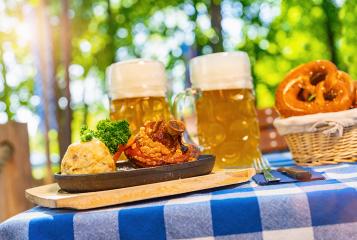Schweinshaxe, traditional Bavarian cuisine with roasted ham hock (pork knuckle) with potato dumpling, brezen and beer mug on a table at beer garden : Stock Photo or Stock Video Download rcfotostock photos, images and assets rcfotostock | RC Photo Stock.: