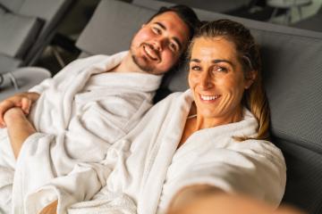 Selfie of smiling couple in white spa robes reclining and looking at camera in a hotel resort- Stock Photo or Stock Video of rcfotostock | RC Photo Stock
