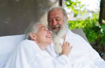Senior couple in love look at each other relaxing together on bed lounge at wellness spa resort. Senior Moments concept image- Stock Photo or Stock Video of rcfotostock | RC Photo Stock