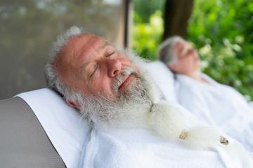 Senior couple relaxing at wellness spa resort. Handsome old man and attractive old woman are enjoying spending time together while lying on deck chair in garden.- Stock Photo or Stock Video of rcfotostock | RC Photo Stock