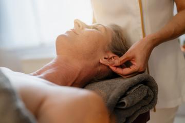 Side view of a massage therapist doing an ear massage for a relaxed female client at a beauty salon : Stock Photo or Stock Video Download rcfotostock photos, images and assets rcfotostock | RC Photo Stock.: