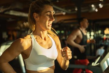 Side view of fit young woman and man while running side by side on modern electric treadmills at the gym- Stock Photo or Stock Video of rcfotostock | RC Photo Stock