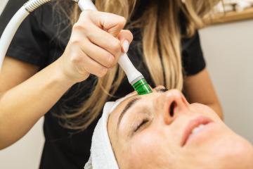 Side view of woman receiving aquafacial therapy on forehead at beauty spa or cosmetology salon. - Stock Photo or Stock Video of rcfotostock | RC Photo Stock